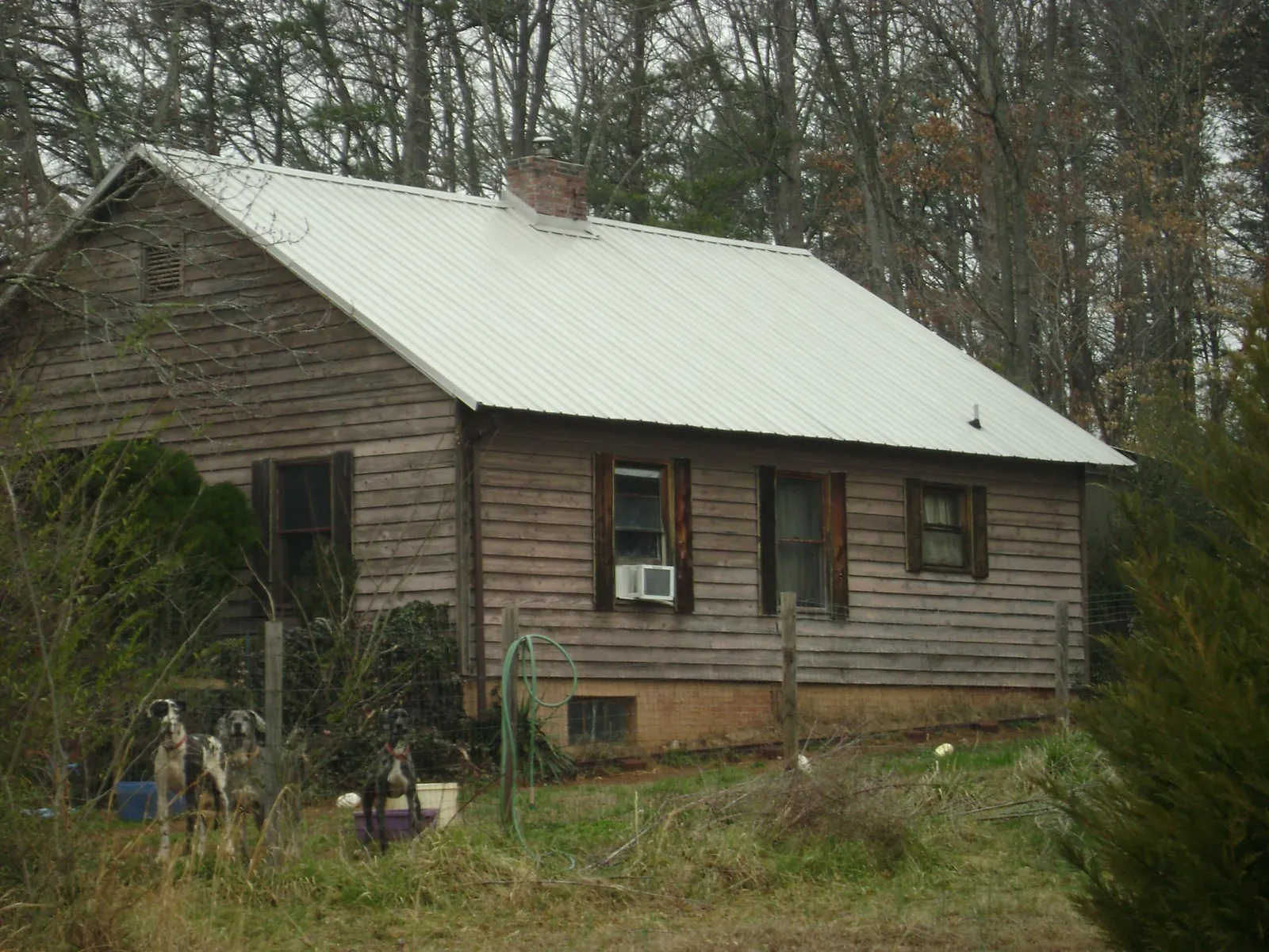 White metal roof on an old wood sided farmhouse, from a Asphalt Shingle Roof Repair job in Ocean Springs